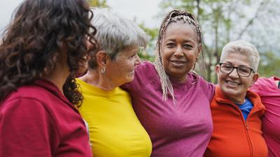Vier vrouwen met de armen om elkaars schouder